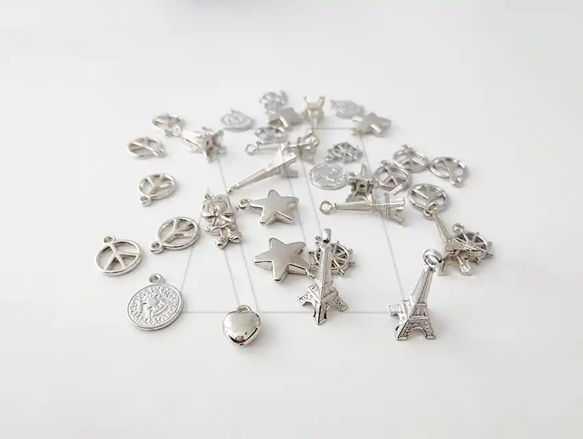 DIJE PLASTICO PLATEADO SURTIDO X 50GRS 136UN APROX