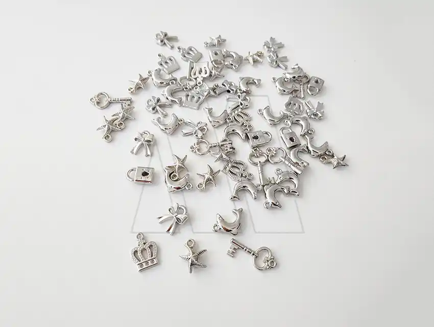 DIJE PLASTICO PLATEADO SURTIDO X 50GRS 152UN APROX