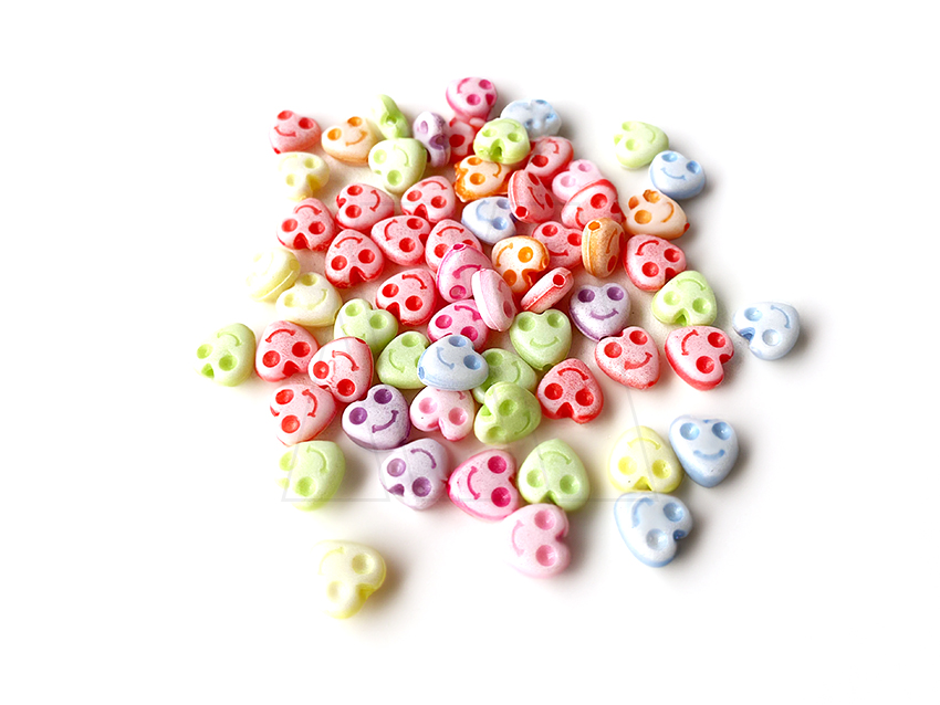 CUENTAS DE PLASTICO CORAZON CON CARITAS 8MM X 125GR